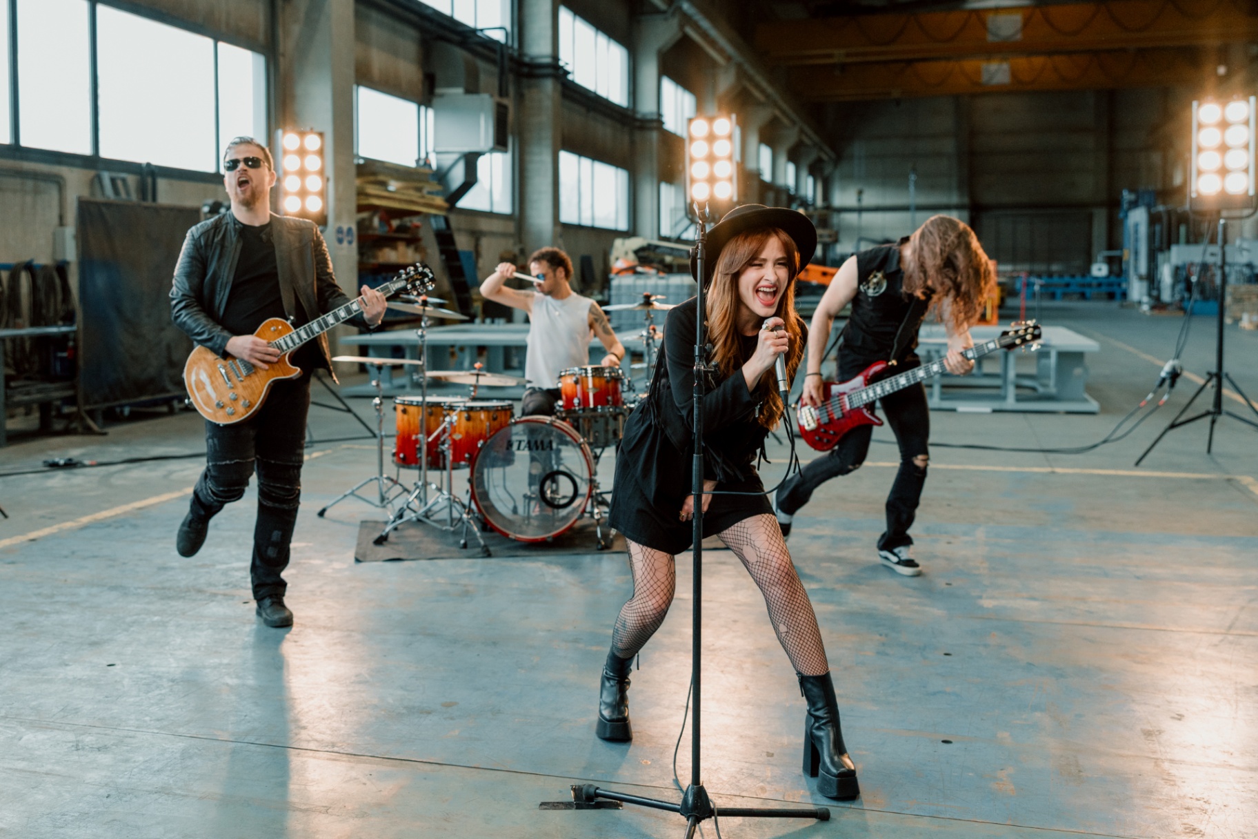 Kati singing into a microphone while the band performs energetically behind her.